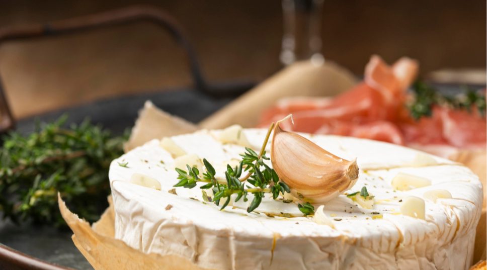 Queso camembert con jamón ibérico al fondo